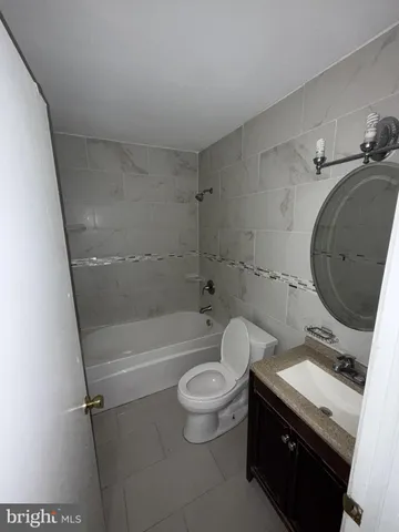 a bathroom with a granite countertop toilet sink and mirror