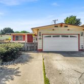 a view of a white house with a yard and plants