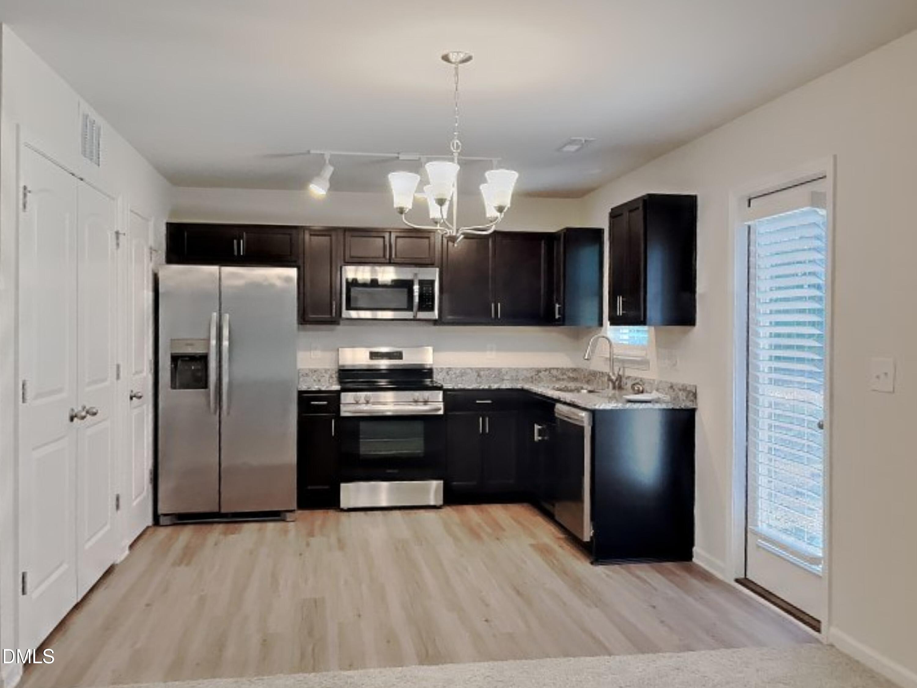 35 Drake Circle Bunnlevel, NC 28323 - Photo 4 of 17 a kitchen with stainless steel appliances granite countertop a refrigerator stove a sink and a microwave