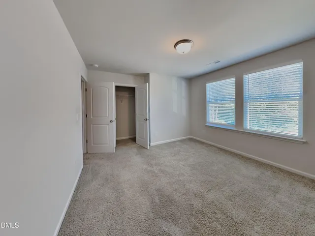 an empty room with windows and closet