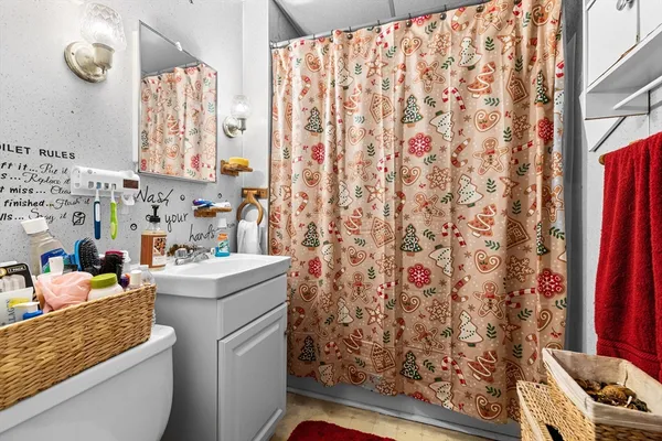 a bathroom with a sink toilet and shower curtain