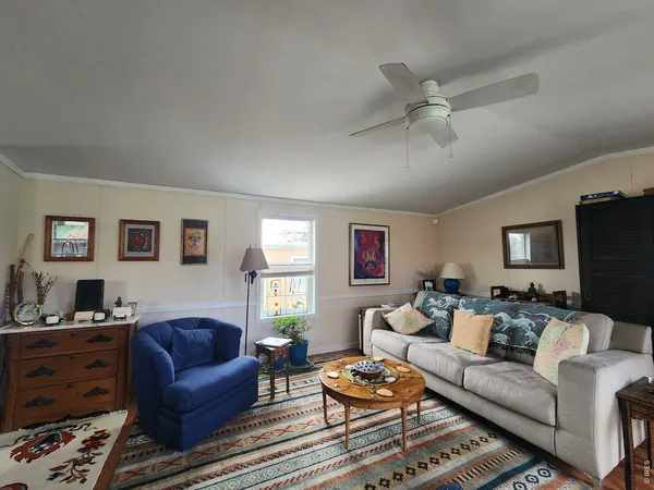 a living room with furniture a ceiling fan and a window