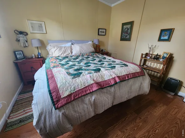 a bedroom with a bed a couch and painting on the wall