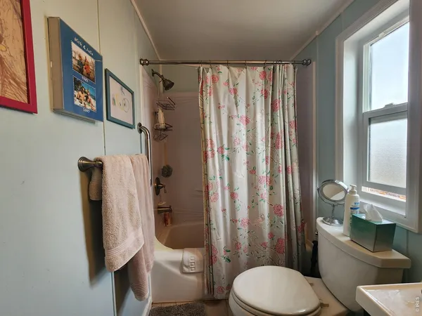 a white toilet sitting next to a bathroom sink and a shower