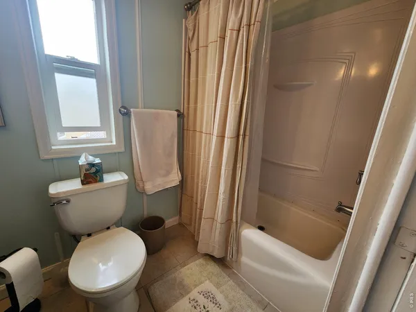 a white toilet sitting next to a bath tub