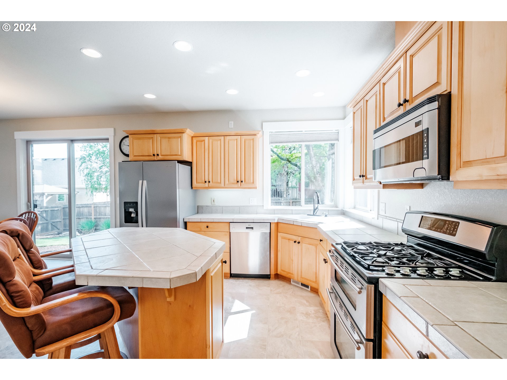 323 Northwest Reed Lane Dallas, OR 97338 - Photo 12 of 40 a kitchen with stainless steel appliances granite countertop a stove a sink dishwasher a dining table and chairs with wooden floor