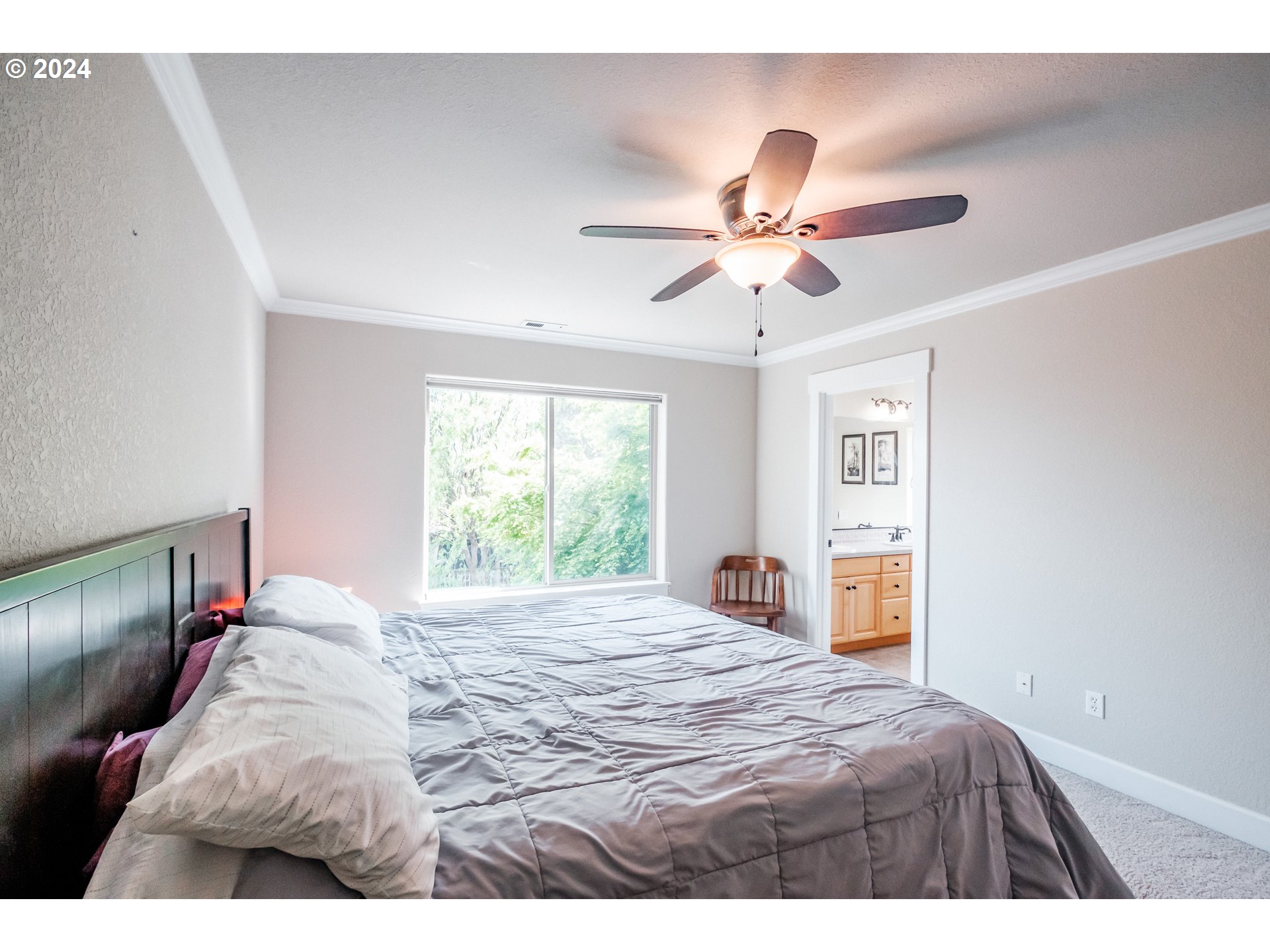 323 Northwest Reed Lane Dallas, OR 97338 - Photo 23 of 40 a bedroom with a bed and a chandelier
