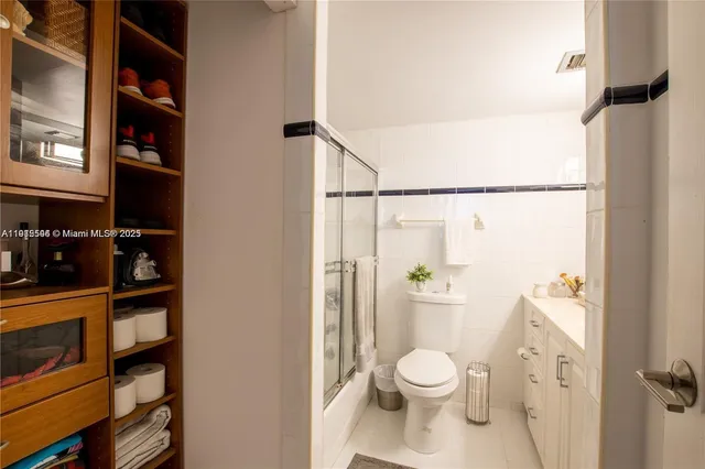 a white toilet sitting next to a bathroom sink and a shower