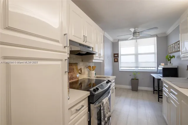 a kitchen with a sink appliances cabinets and a window