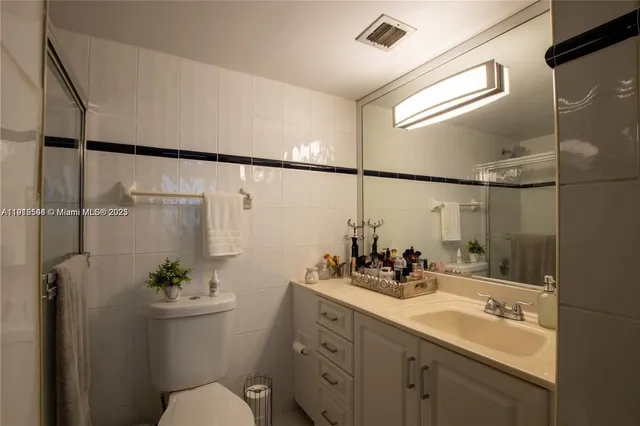 a bathroom with a double vanity sink toilet and a shower