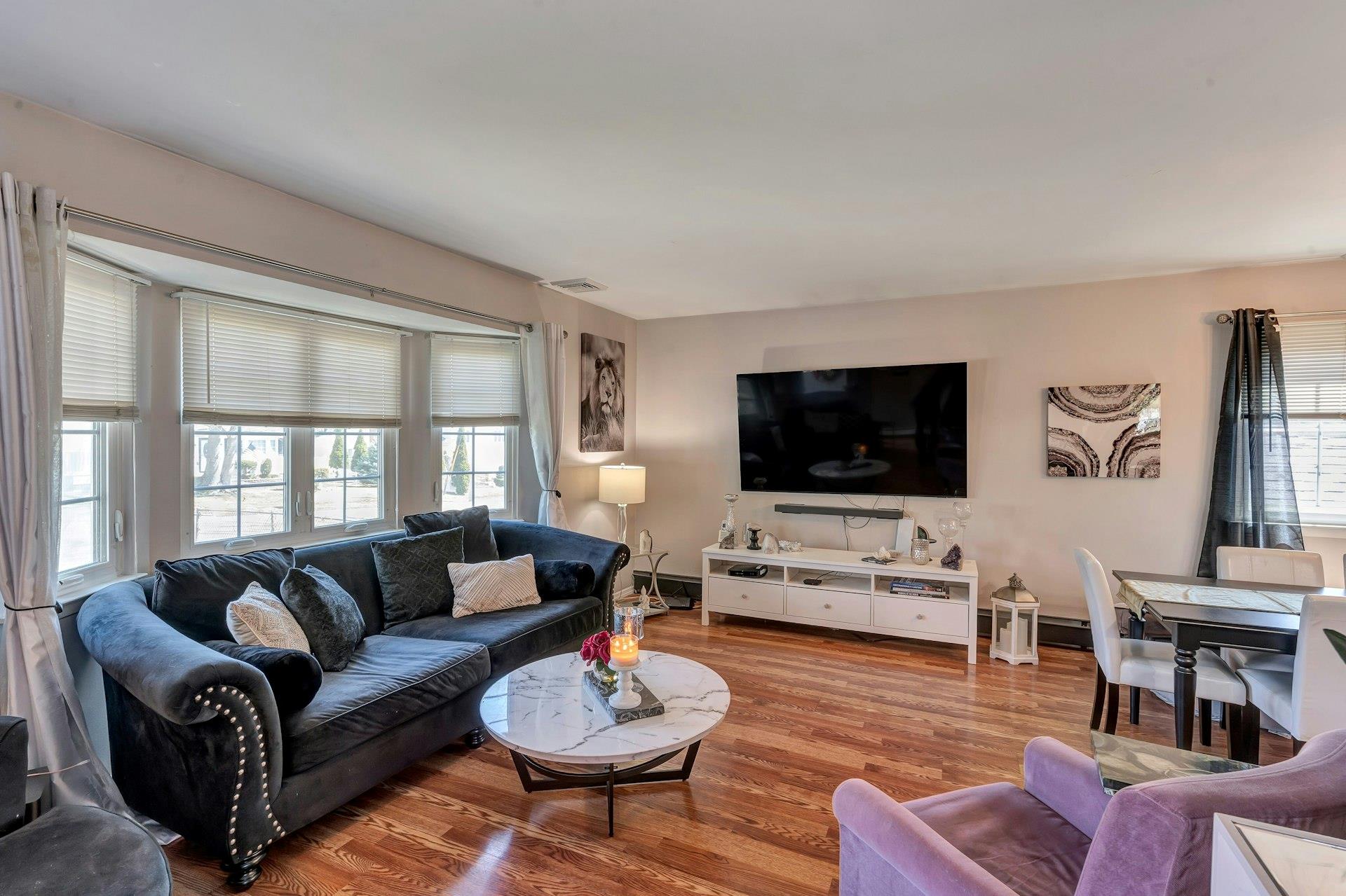 416 Blue Point Road Farmingville, NY 11738 - Photo 1 of 1 Living area with visible vents, baseboards, wood finished floors, and a healthy amount of sunlight