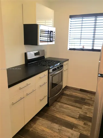 a kitchen with stainless steel appliances a stove and a microwave