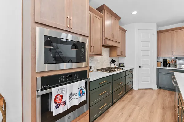 a kitchen with stainless steel appliances a stove a microwave and cabinets