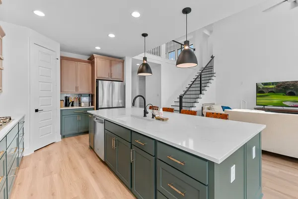 a kitchen with kitchen island a sink stainless steel appliances and cabinets