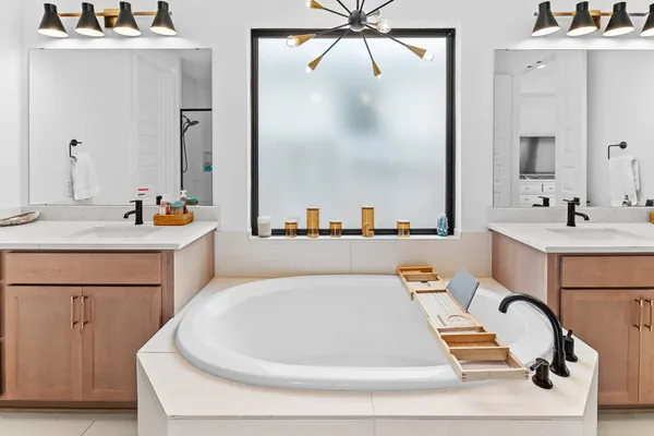 a bathroom with a sink a tub and a mirror