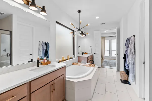 a bathroom with a tub sink and mirror