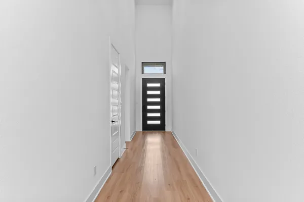 a view of a hallway with wooden floor and entryway
