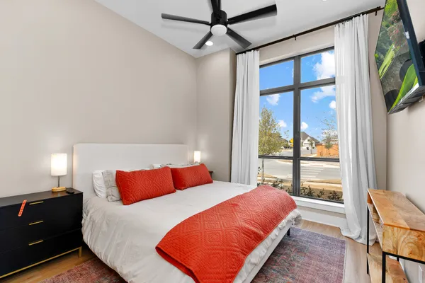 a bedroom with a bed and a flat tv screen on dresser