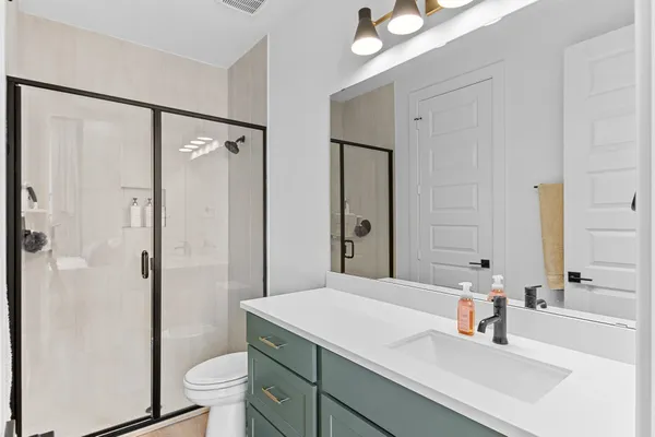 a bathroom with a sink a toilet and shower