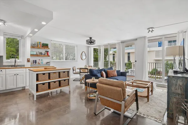 a living room with furniture and a kitchen view
