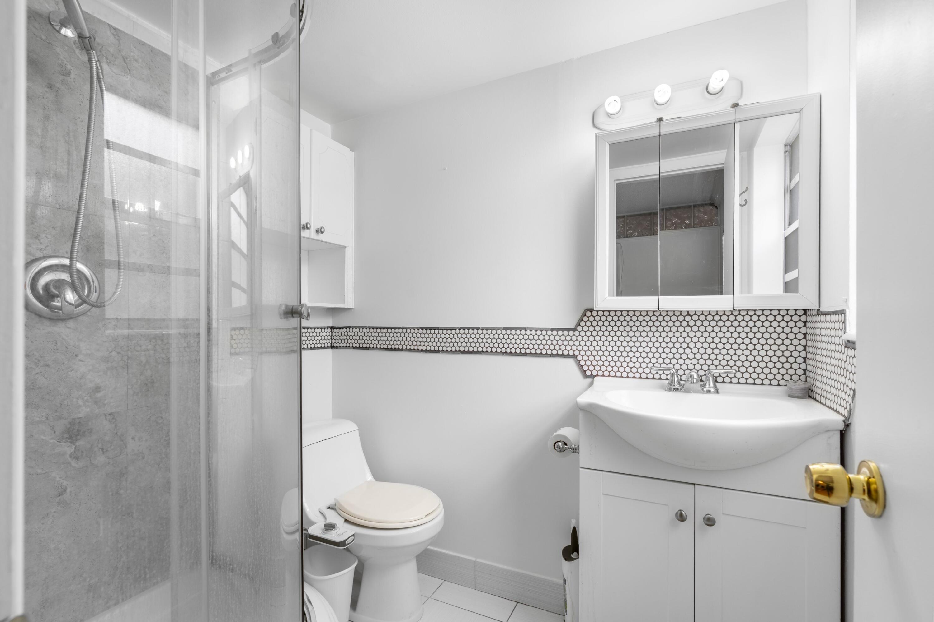 5501 Northwest 2nd Avenue, Unit 213 Boca Raton, FL 33487 - Photo 13 of 17 a bathroom with a sink toilet and shower