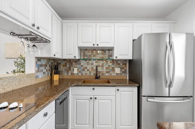 a kitchen with stainless steel appliances granite countertop a refrigerator and a sink