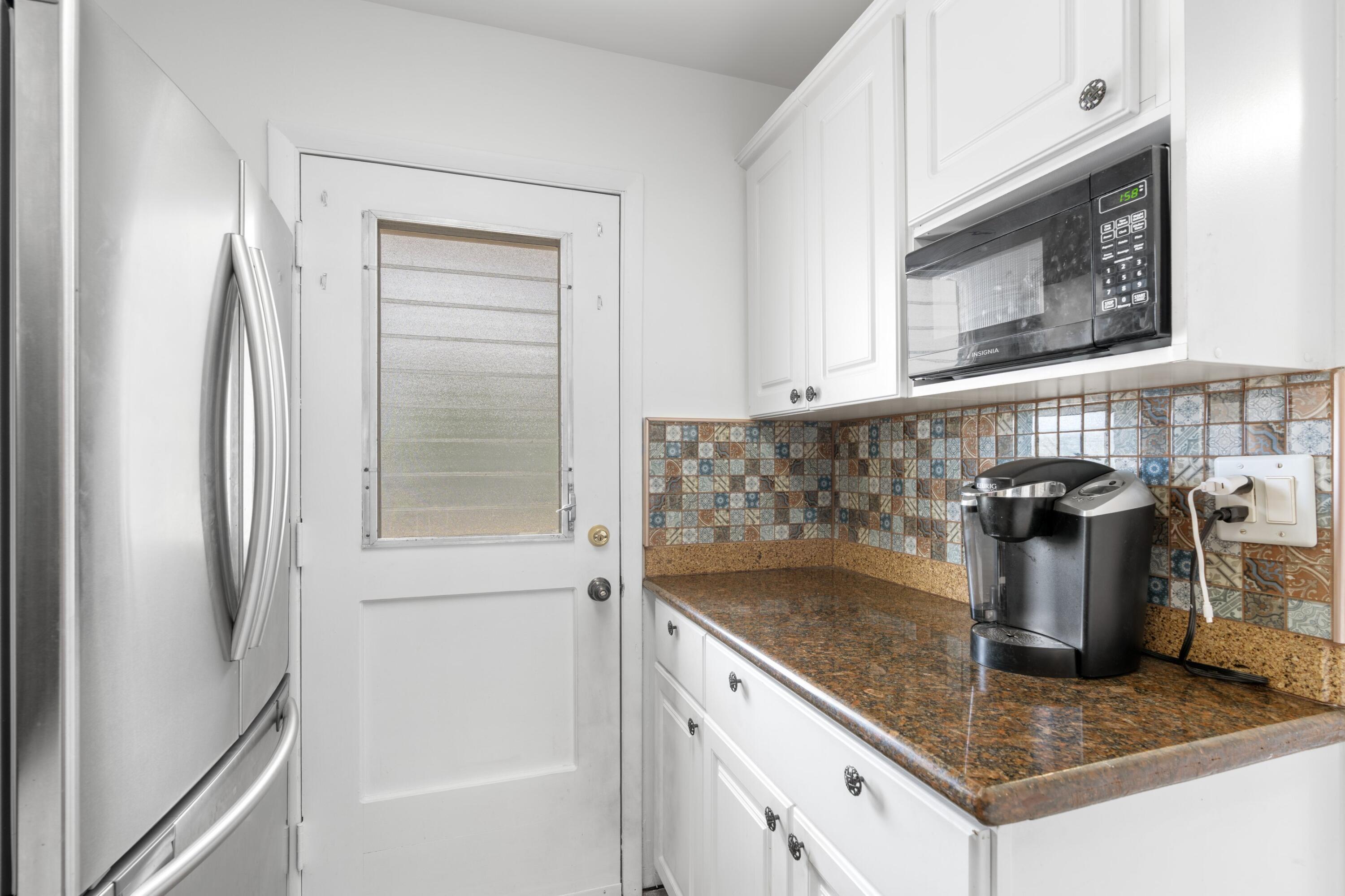 5501 Northwest 2nd Avenue, Unit 213 Boca Raton, FL 33487 - Photo 3 of 17 a kitchen with a refrigerator and a sink