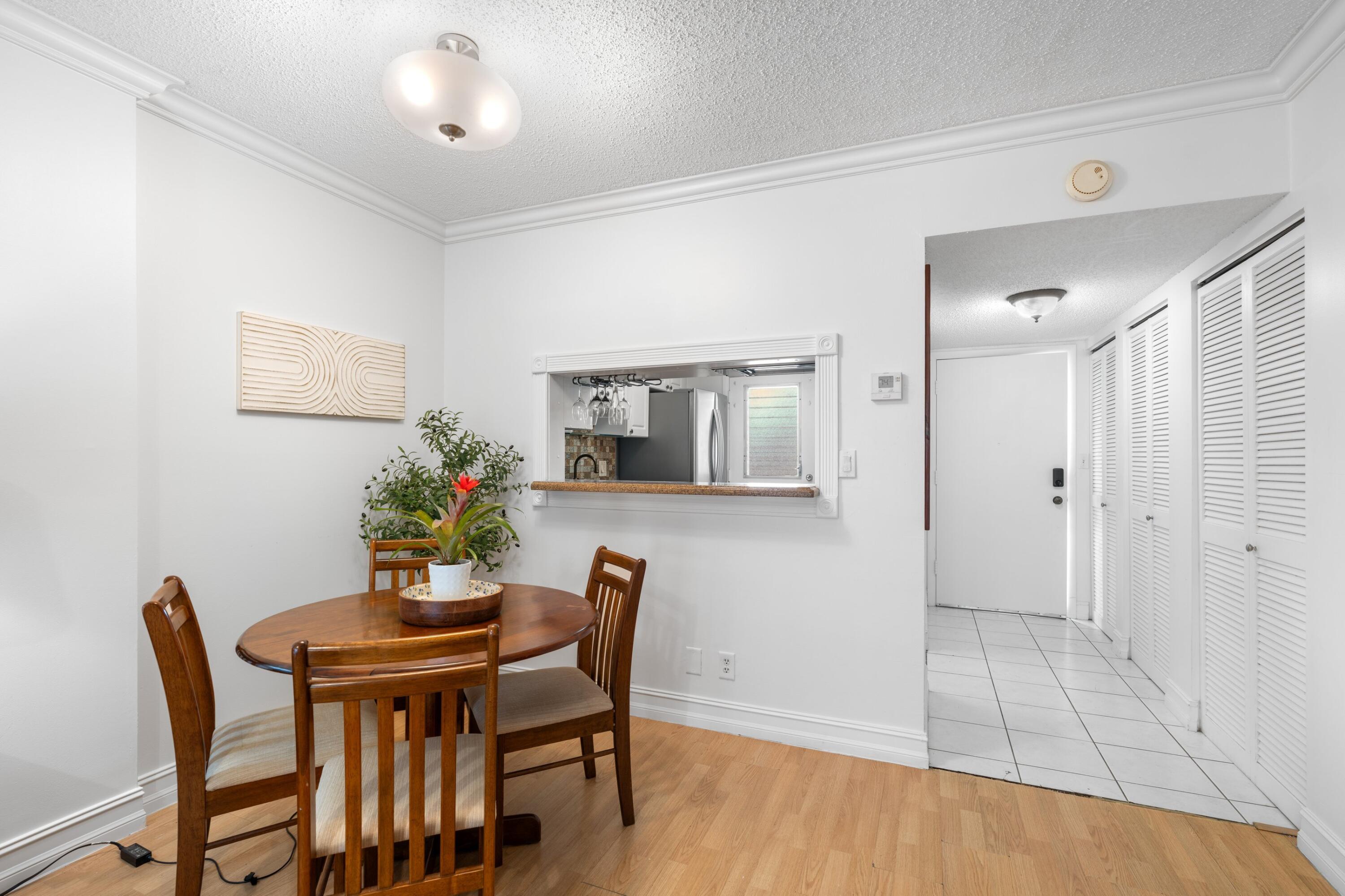 5501 Northwest 2nd Avenue, Unit 213 Boca Raton, FL 33487 - Photo 4 of 17 a view of a dining room with furniture and wooden floor
