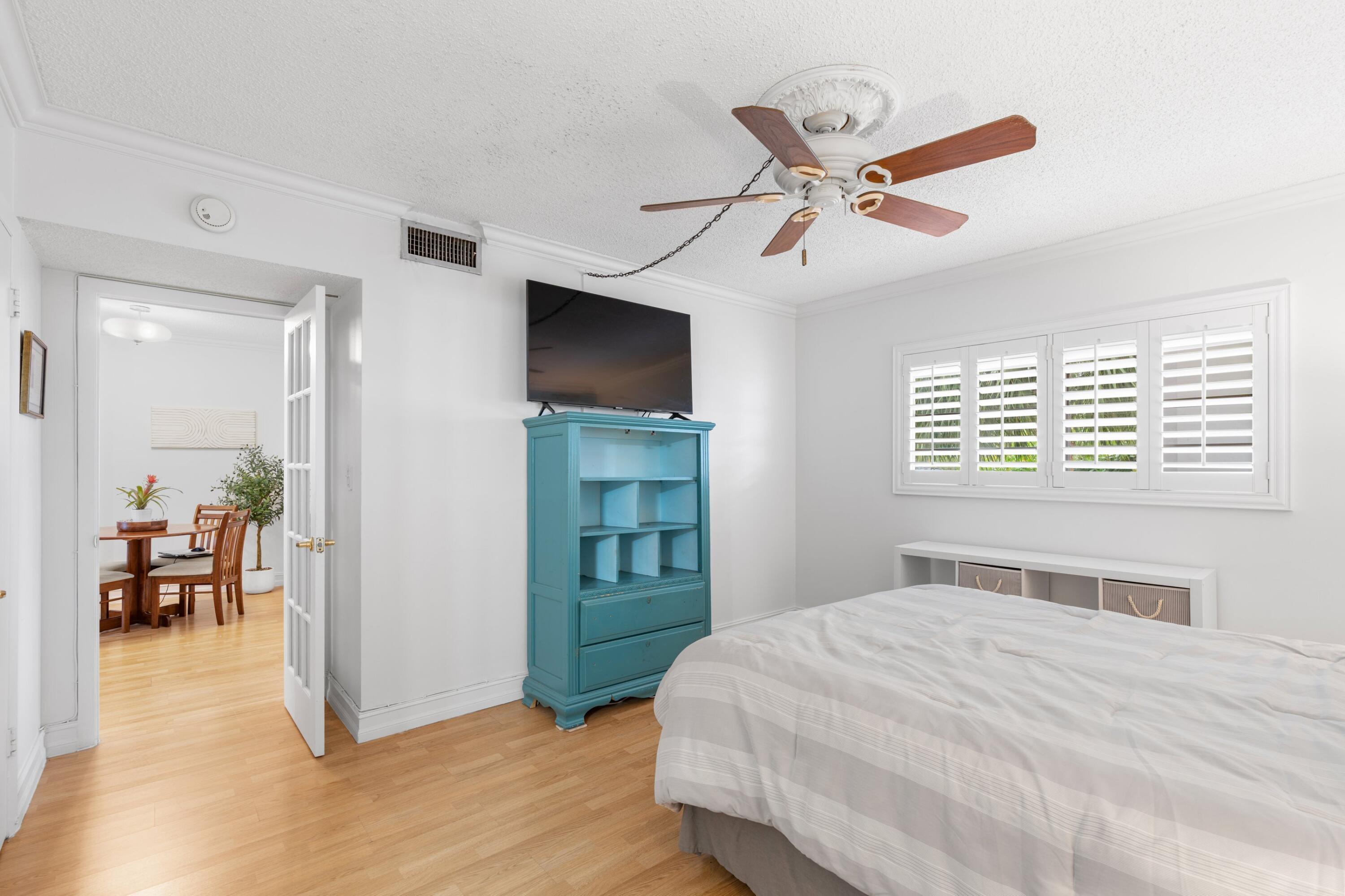 5501 Northwest 2nd Avenue, Unit 213 Boca Raton, FL 33487 - Photo 9 of 17 a bedroom with a bed and a flat screen tv