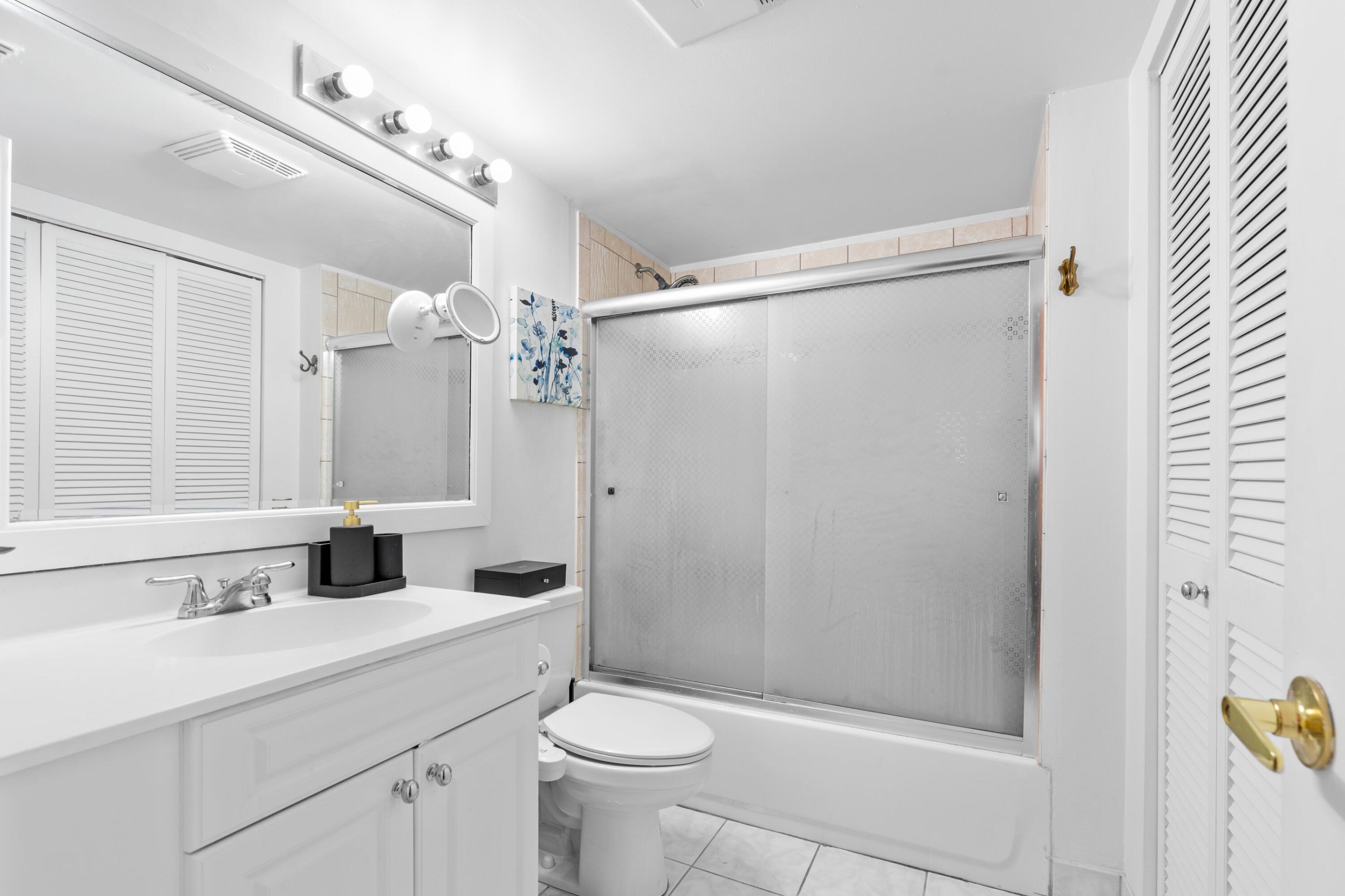5501 Northwest 2nd Avenue, Unit 213 Boca Raton, FL 33487 - Photo 10 of 17 a bathroom with a shower sink vanity mirror and toilet