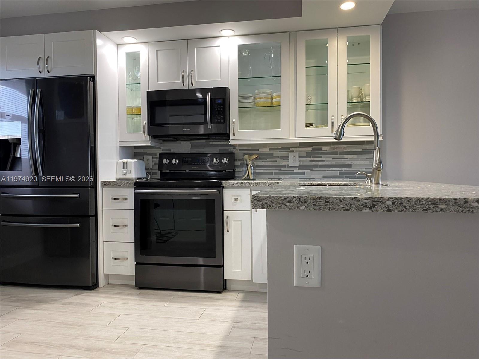 a kitchen with granite countertop a stove and a refrigerator