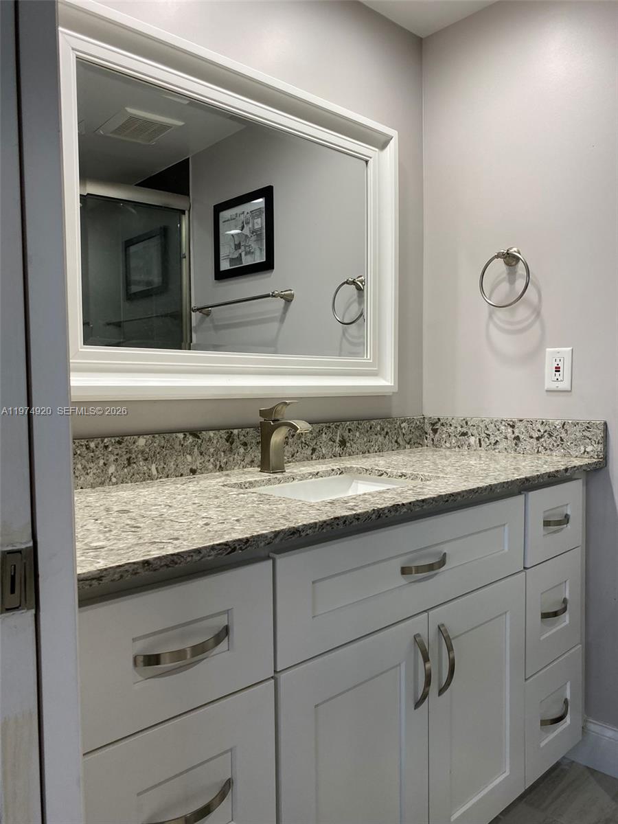 2929 South Ocean Boulevard, Unit 5090 Boca Raton, FL 33432 - Photo 14 of 25 a bathroom with a granite countertop sink and a mirror