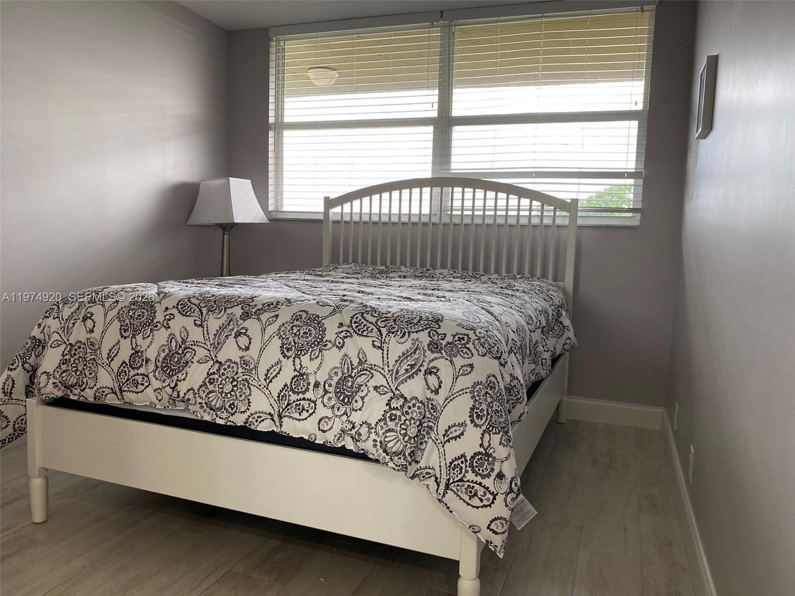 2929 South Ocean Boulevard, Unit 5090 Boca Raton, FL 33432 - Photo 18 of 25 a bed sitting in a bedroom next to a window