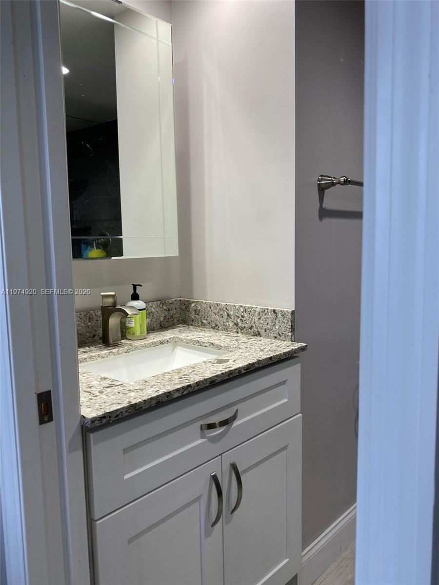 2929 South Ocean Boulevard, Unit 5090 Boca Raton, FL 33432 - Photo 19 of 25 a bathroom with a granite countertop sink and a mirror