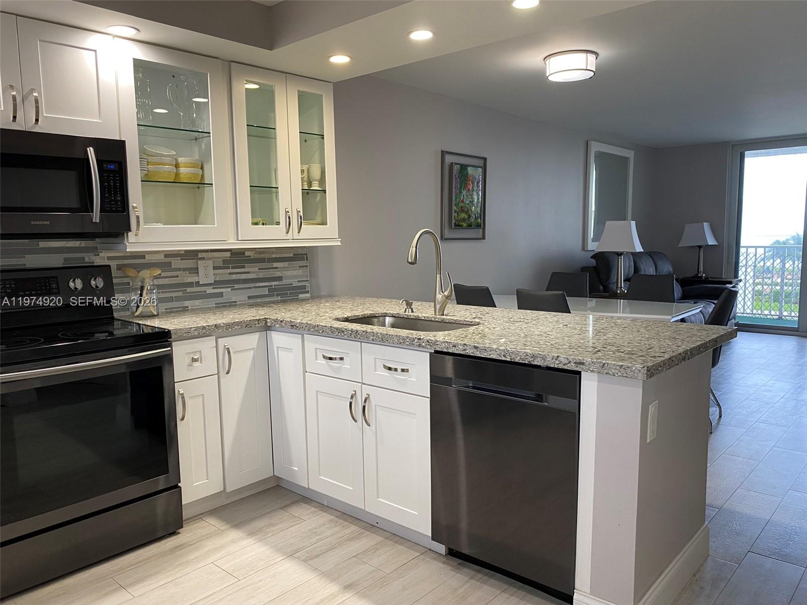 2929 South Ocean Boulevard, Unit 5090 Boca Raton, FL 33432 - Photo 2 of 25 a kitchen with granite countertop stainless steel appliances a stove sink and microwave