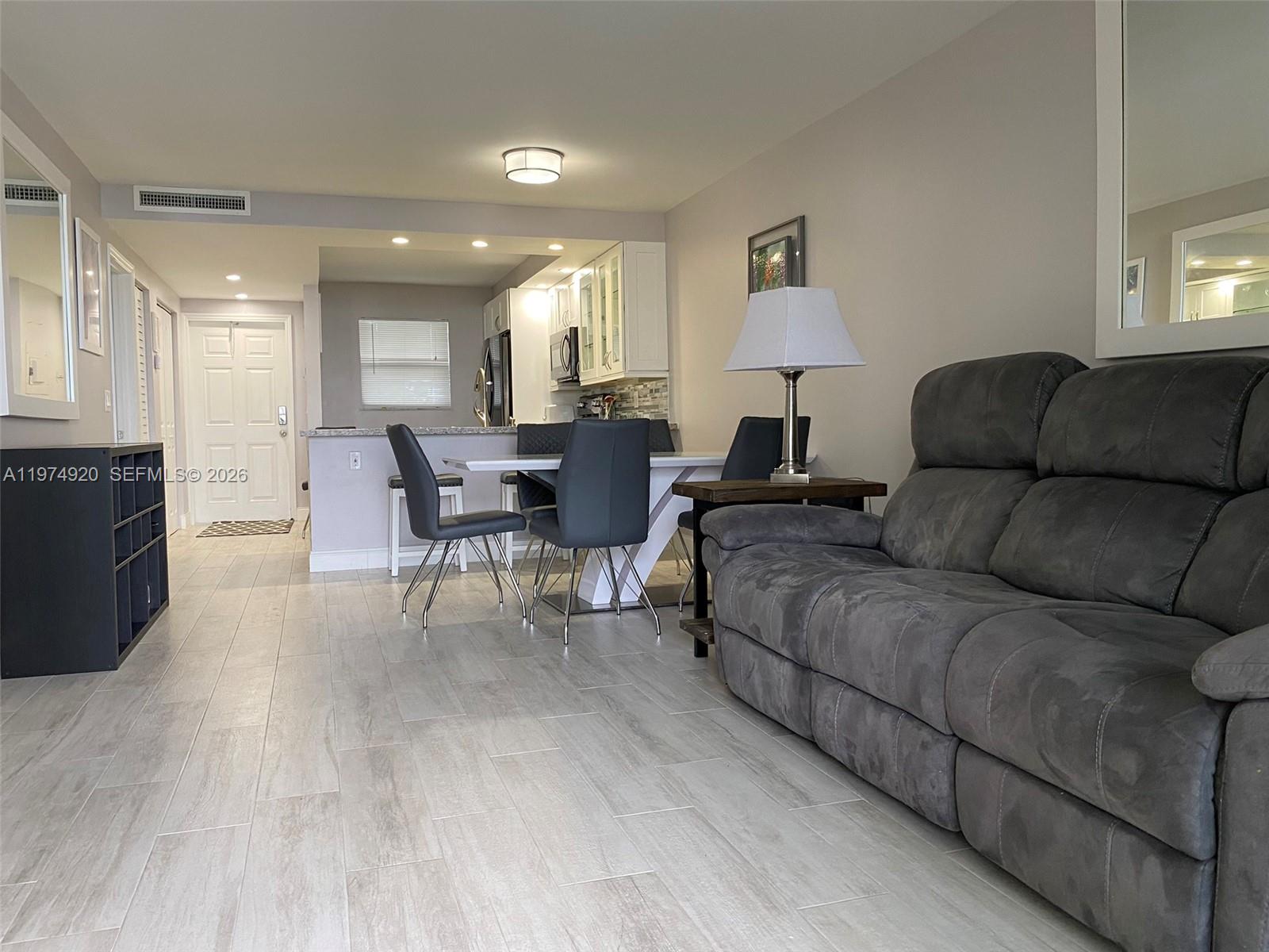 2929 South Ocean Boulevard, Unit 5090 Boca Raton, FL 33432 - Photo 8 of 25 a living room with furniture and a wooden floor