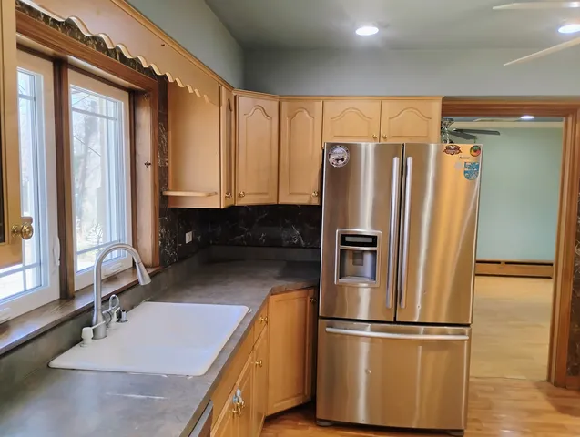 a kitchen with stainless steel appliances granite countertop a refrigerator and a sink