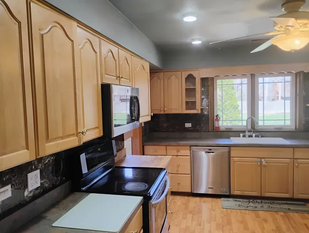 a kitchen with stainless steel appliances granite countertop a stove a sink and a microwave