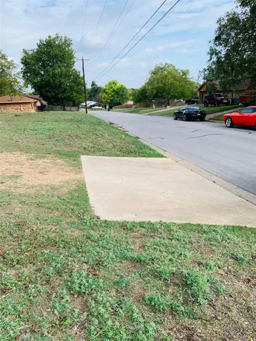 a view of a street with a car parked in the background