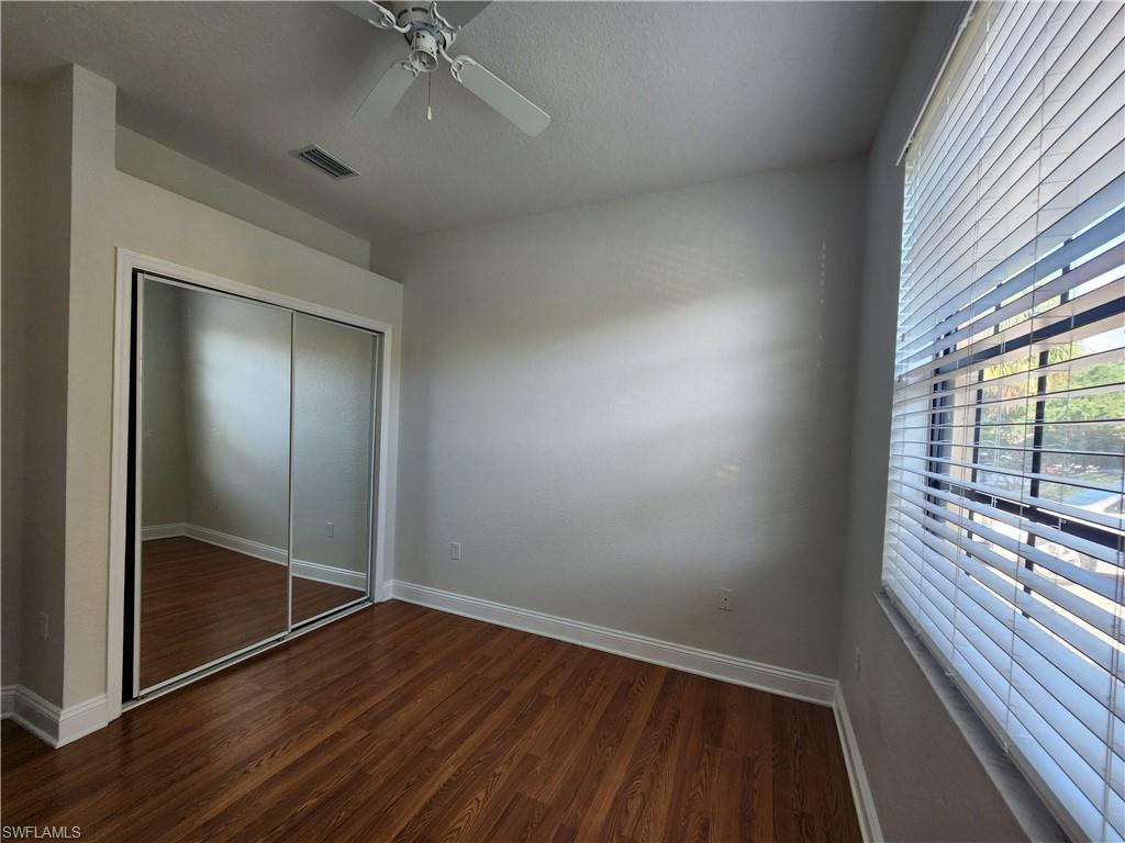 7512 Bristol Circle Naples, FL 34120 - Photo 12 of 22 an empty room with wooden floor and windows
