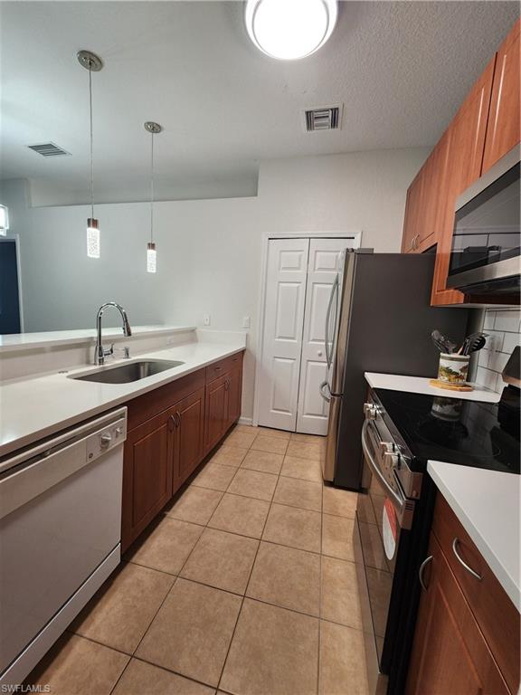 7512 Bristol Circle Naples, FL 34120 - Photo 4 of 22 a kitchen with a sink a stove and a refrigerator