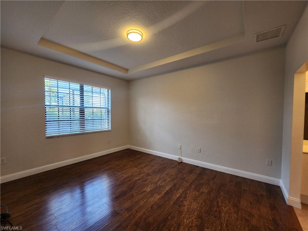 7512 Bristol Circle Naples, FL 34120 - Photo 8 of 22 an empty room with wooden floor and windows