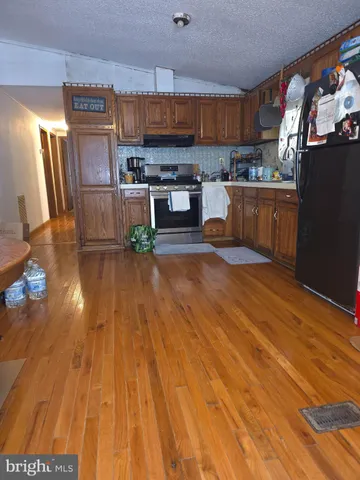 a kitchen with stainless steel appliances wooden floors and wooden cabinets