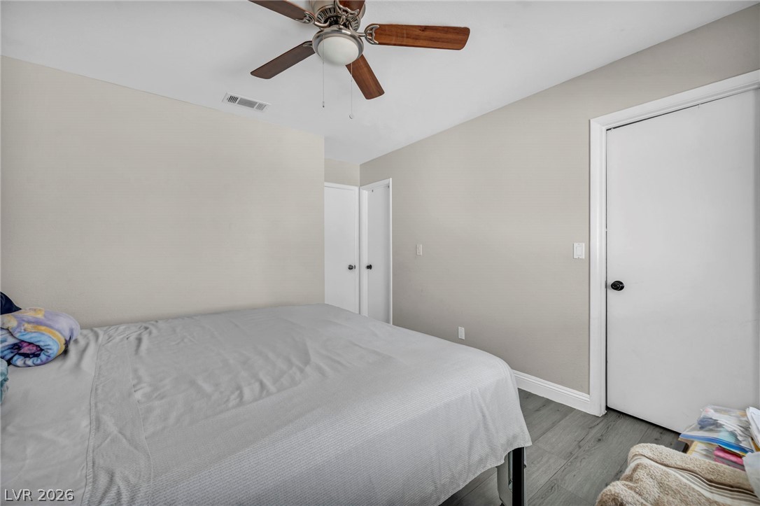 5882 Rio Tinto Way Las Vegas, NV 89110 - Photo 17 of 56 Well-lit sleeping quarters with elegant wood flooring and a modern ceiling fan for comfort.