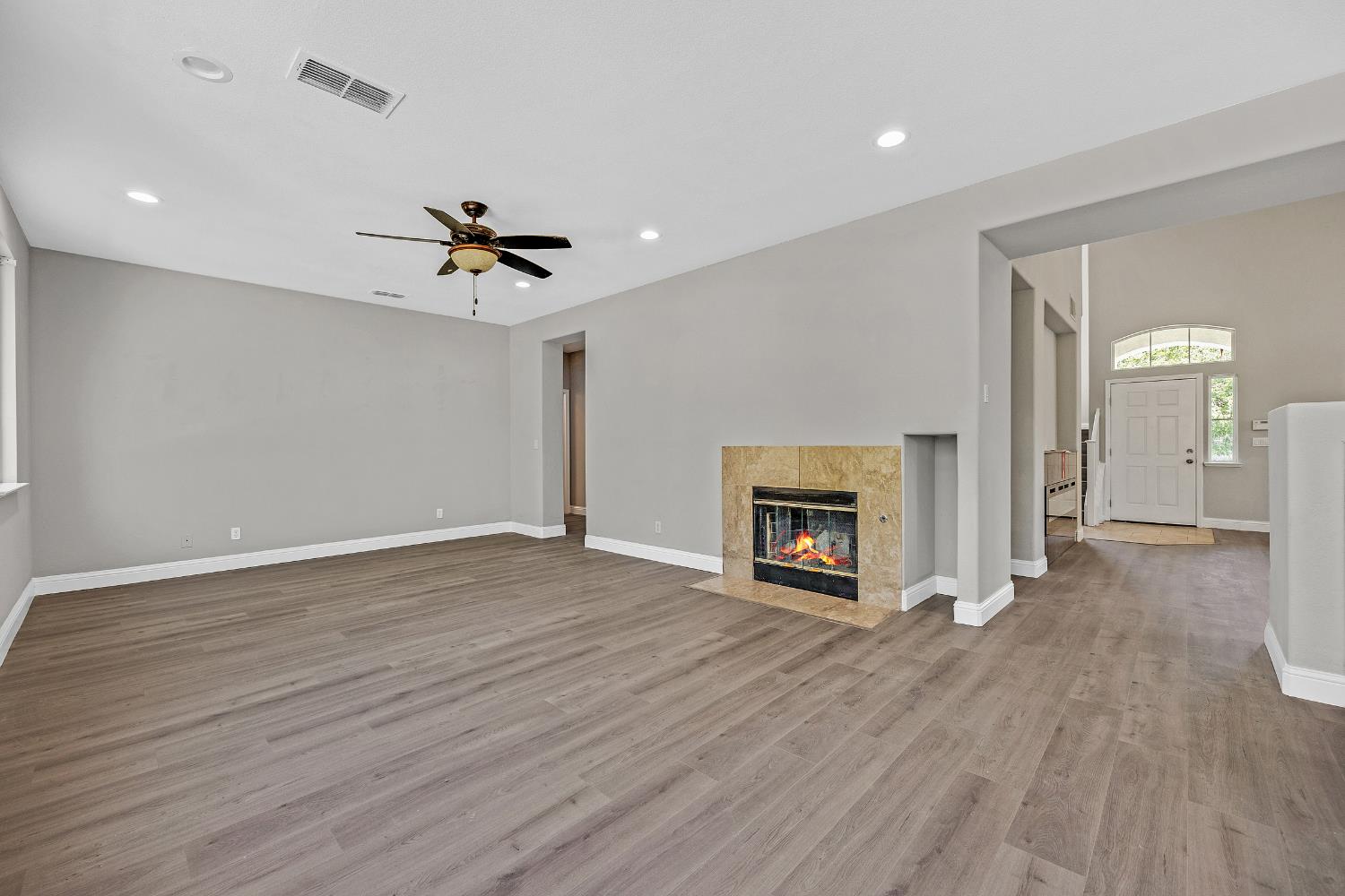 2963 Rugby Court Tracy, CA 95377 - Photo 12 of 40 a view of a livingroom with a fireplace a chandelier and wooden floor