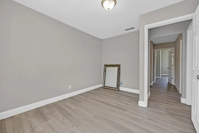 a view of an empty room with wooden floor