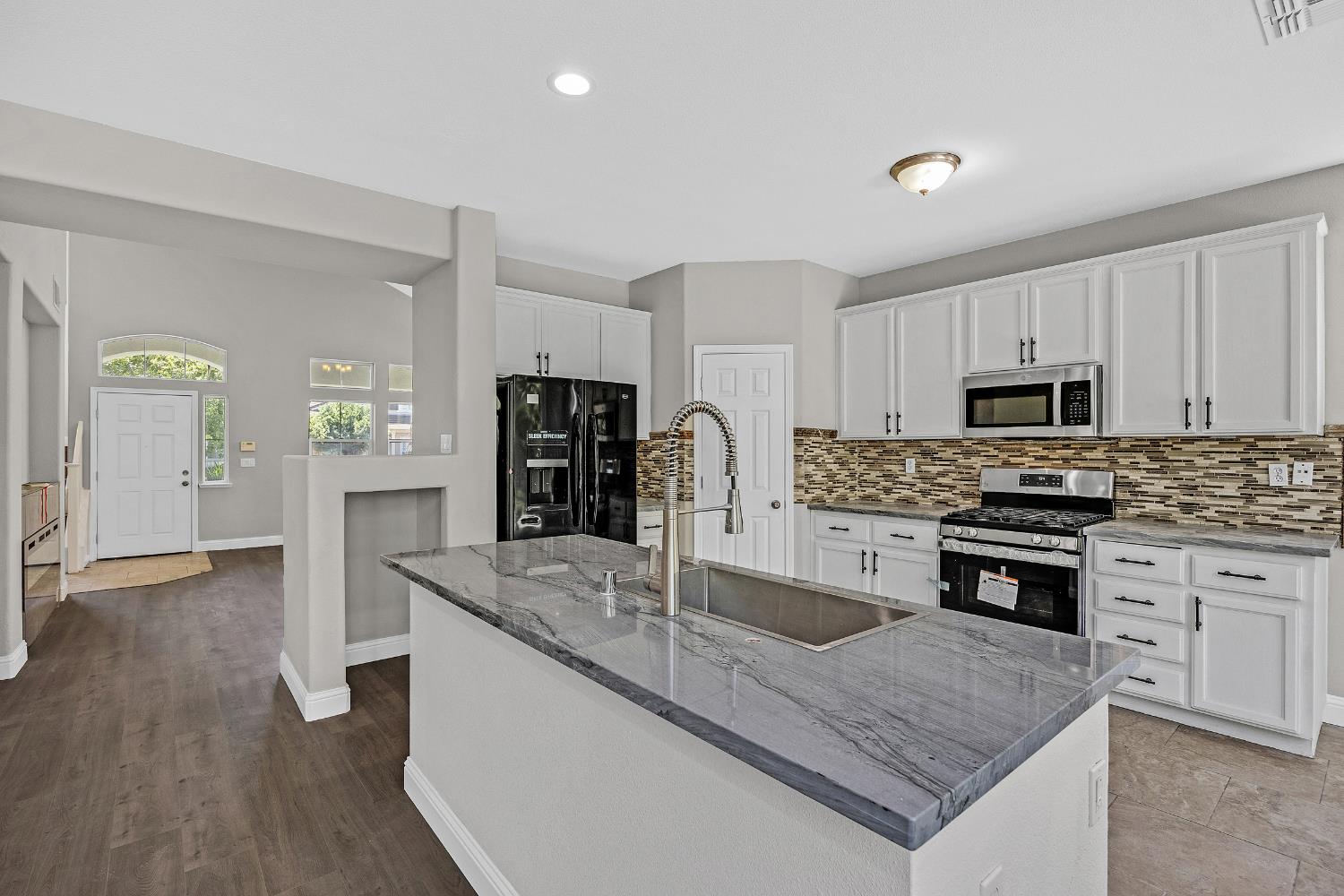 2963 Rugby Court Tracy, CA 95377 - Photo 8 of 40 a kitchen with stainless steel appliances granite countertop a stove a sink and a refrigerator