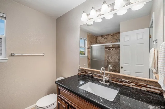 a bathroom with a sink a toilet and a mirror