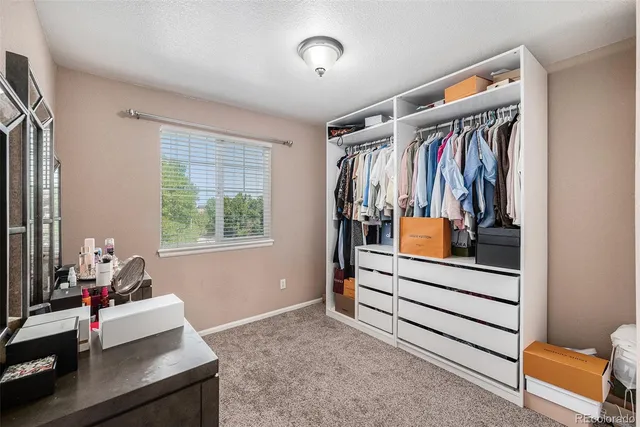 a view of walk in closet with clothes and shoes