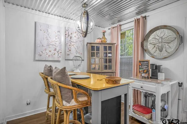 a dining room with a wooden table and chairs
